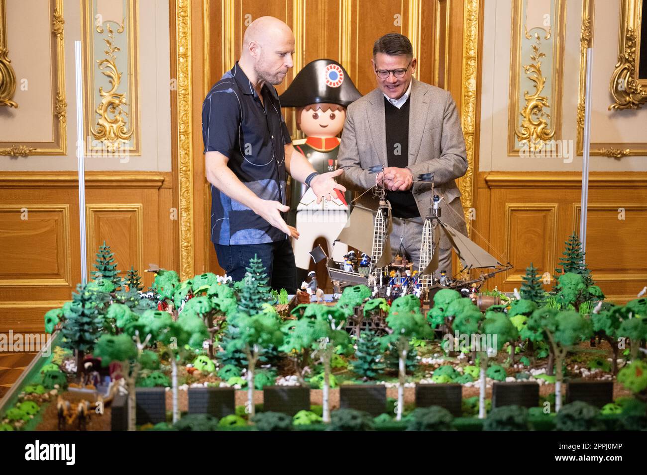 Hanau, Deutschland. 24. April 2023. Boris Rhein (CDU, r), Ministerpräsident von Hessen, spricht mit dem Künstler Oliver Schaffer auf einer Playmobil-Ausstellung über 175 Jahre Frankfurter Paulskirche im Hanau History Museum in der Burg Philippsruhe. Die Ausstellung zeigt die Geschichte der deutschen Demokratie in elf Dioramen, die aus Tausenden von Playmobil-Teilen bestehen. Kredit: Sebastian Christoph Gollnow/dpa/Alamy Live News Stockfoto