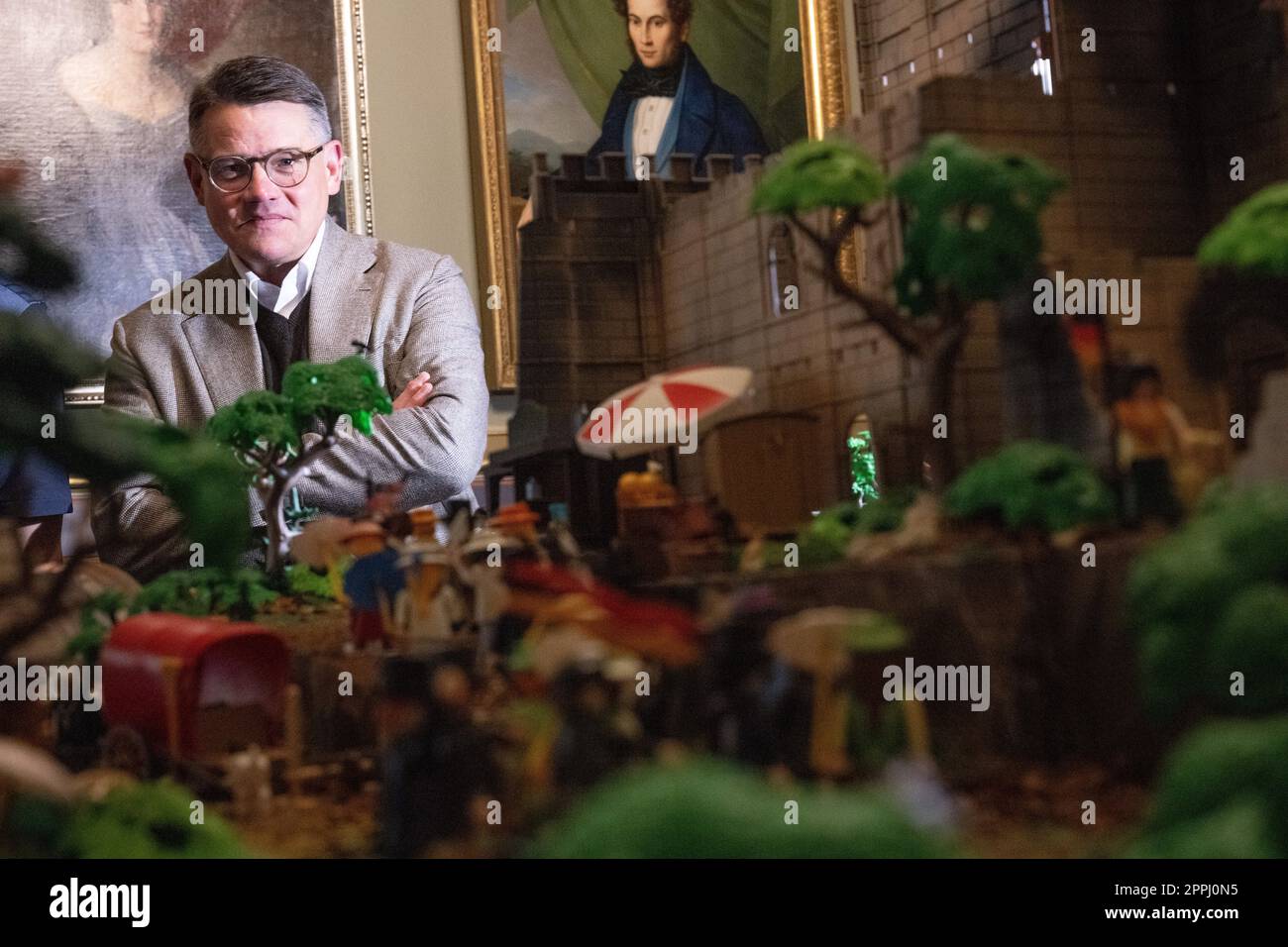 Hanau, Deutschland. 24. April 2023. Boris Rhein (CDU), Ministerpräsident von Hessen, steht hinter einem Playmobil-Diorama des Hambach-Festivals in einer Playmobil-Ausstellung, die 175 Jahre Frankfurts Paulskirche im Hanau History Museum in der Burg Philippsruhe feiert. Die Ausstellung zeigt die Geschichte der deutschen Demokratie in elf Dioramen, die aus Tausenden von Playmobil-Teilen bestehen. Kredit: Sebastian Christoph Gollnow/dpa/Alamy Live News Stockfoto