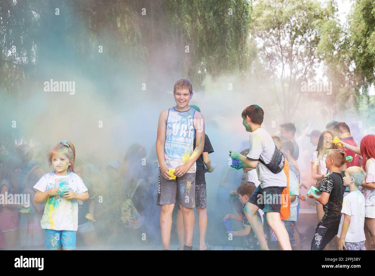 Lemberg, Ukraine - 18. Juli 2021: Color Holi Festival, eine Menschenmenge von Erwachsenen und kleinen Kindern werfen farbenfrohe Farben. Indianerfeiertag, Kinder laufen auf einer Holzbühne. Stockfoto