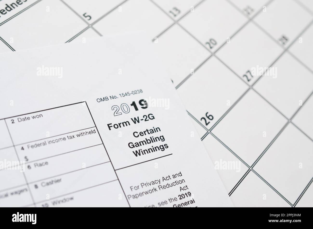 Das IRS-Formular W-2G bestimmte Glücksspiel-Sieger ist leer und liegt auf einer leeren Kalenderseite Stockfoto