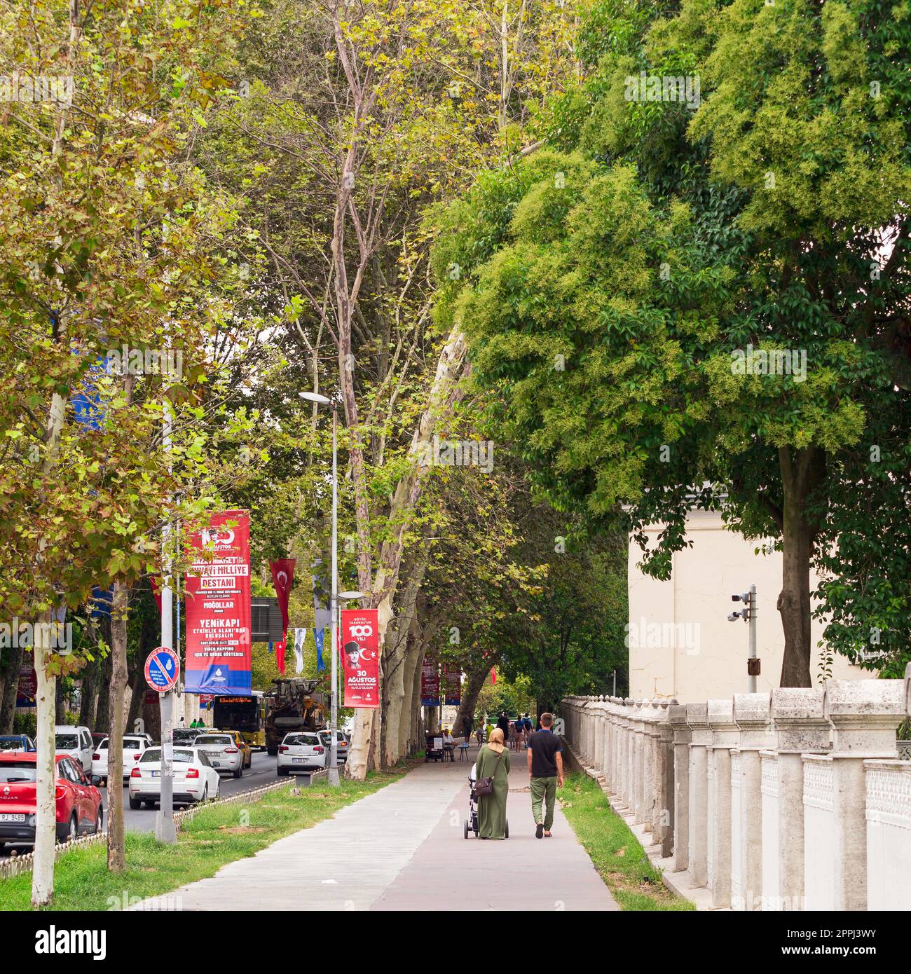 Fußgänger, die im Sommer in einer Passage mit riesigen Bäumen im Gulhane Park spazieren, Sultan Ahmet, Istanbul, Türkei Stockfoto