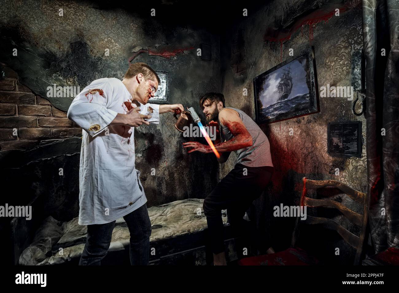 Psycho-Killer foltert mit Gasbrenner unglückliches Opfer Stockfoto