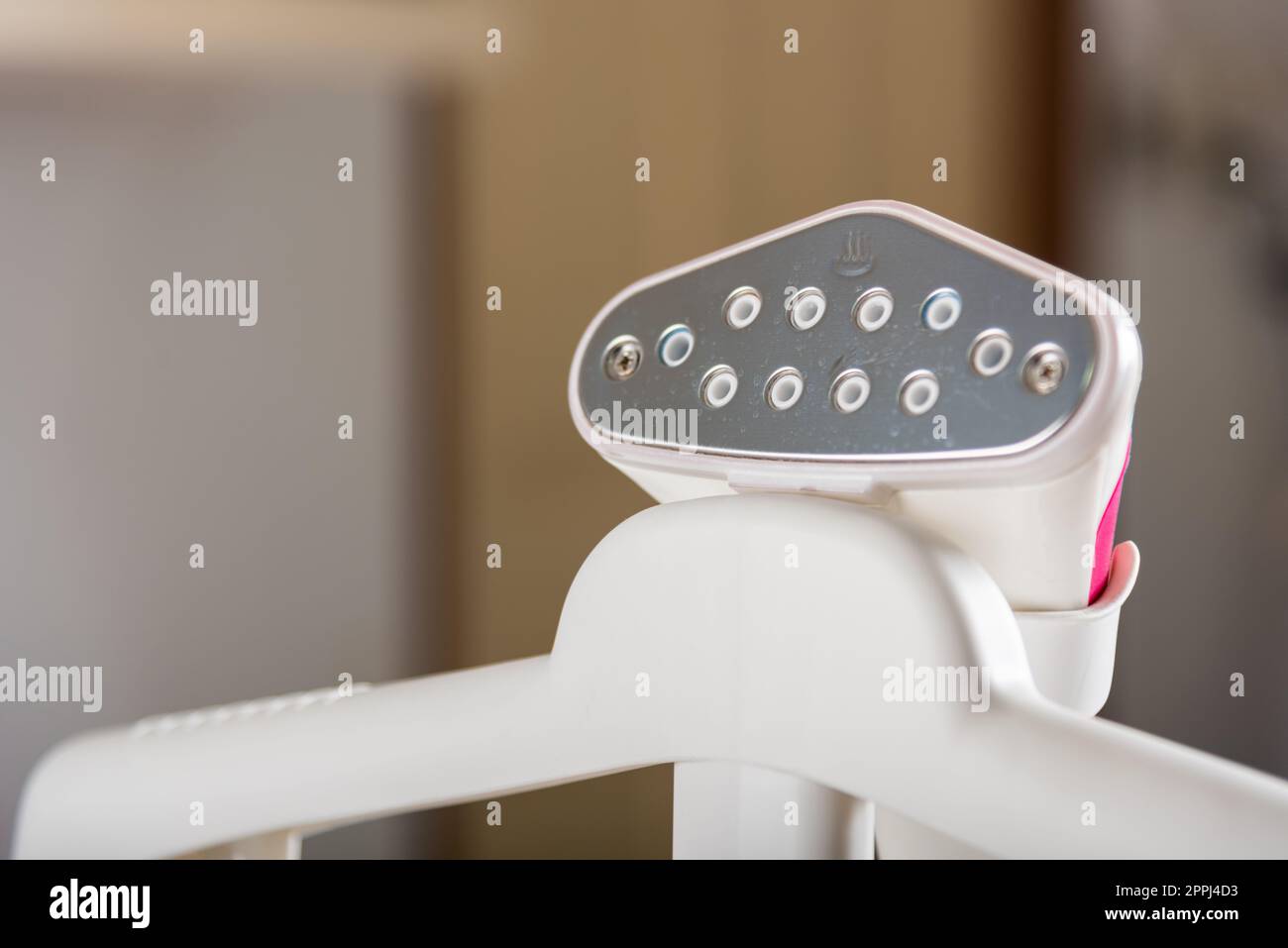 Nahaufnahme der elektrischen Hand-Dampfeinheit, während es auf dem Bügelbrett heiß für Kleidung ist Stockfoto