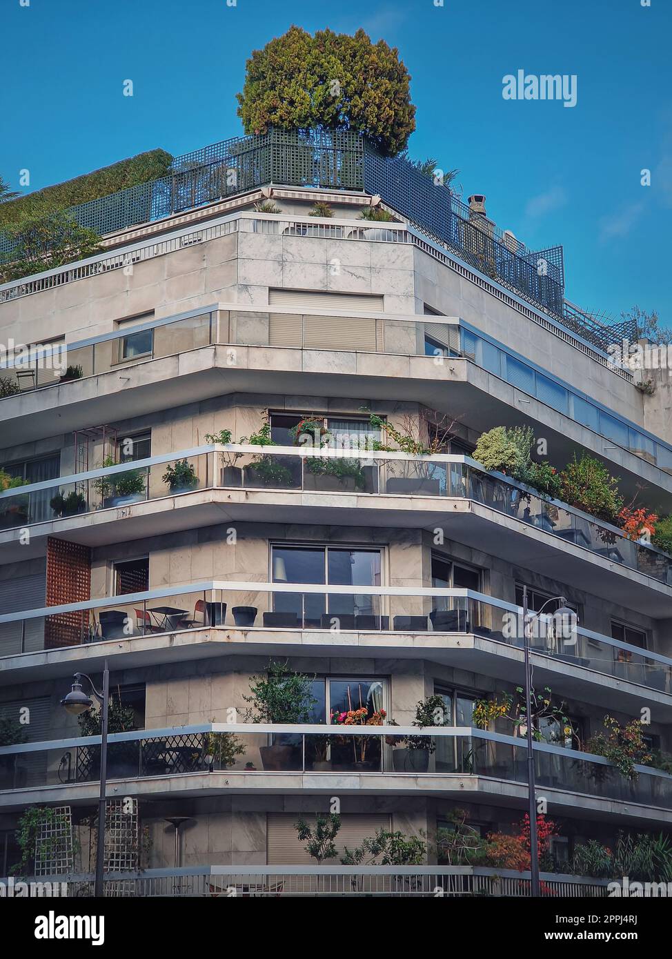 Grünes, umweltfreundliches Gebäude mit verschiedenen Pflanzen und Bäumen auf den Balkonen und auf dem Dach in Paris, Frankreich. Städtisches Umfeld, Ökologisierungskonzept Stockfoto