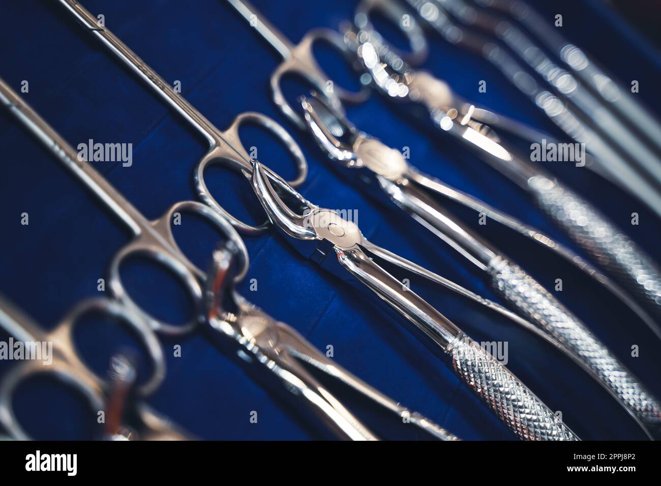 Reihe verschiedener Dentalwerkzeuge auf blauem Hintergrund mit geringer Schärfentiefe Stockfoto