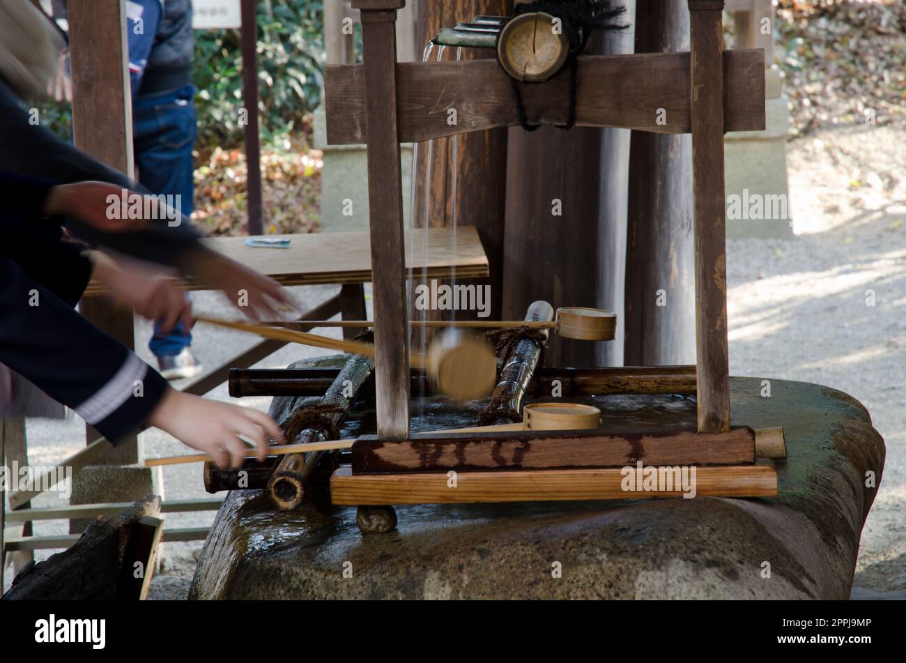 Personen in einem traditionellen Brunnen zur Abreinigung. Stockfoto