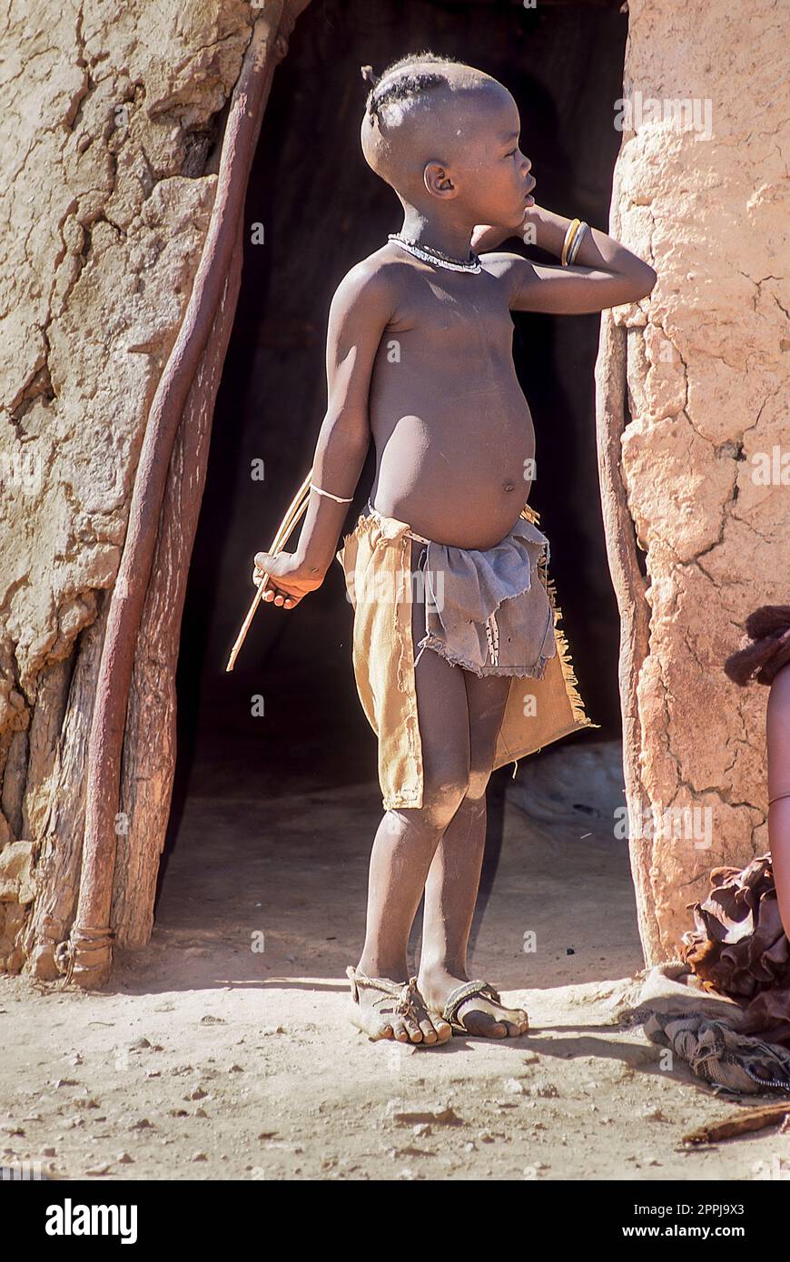 15. Mai 2005. Unidentifizierter himba-Junge in der traditionellen Hütte, Epupa Falls, Kaokoland oder Kunene Province, Namibia, Afrika Stockfoto