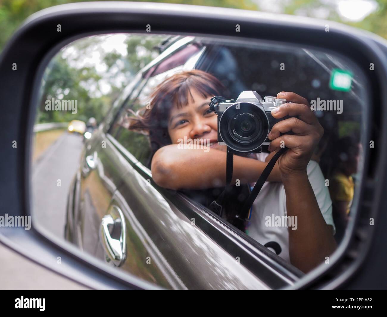 Eine Frau hält eine Digitalkamera in der Hand und macht ein Bild von sich selbst, das im Spiegel reflektiert wird. Stockfoto