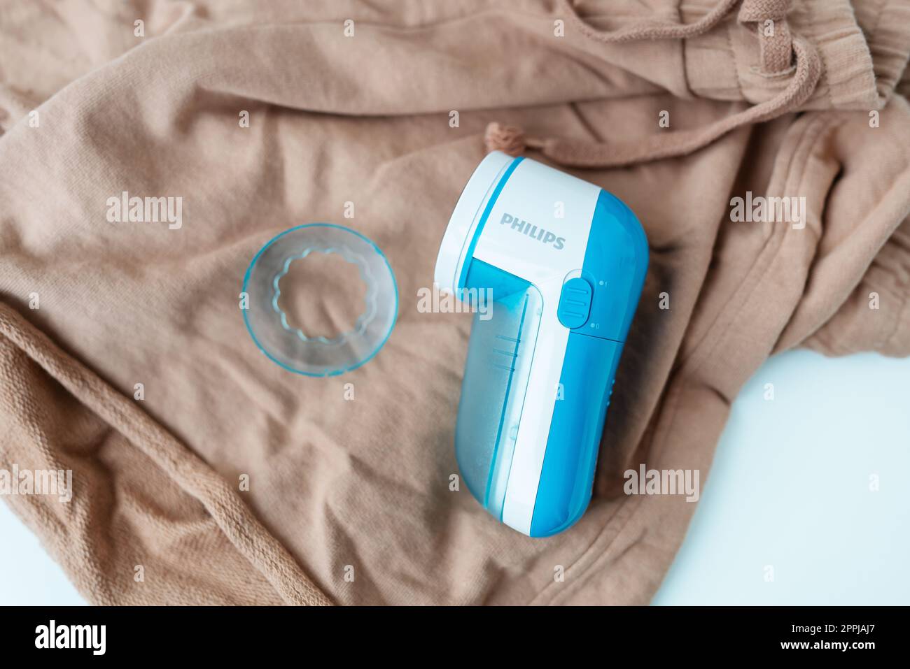 Kiew, Ukraine – 17. Dezember 2022: Philips Gerät entfernt große Spulen mit einem elektronischen Gerät von der Kleidung. Das Konzept der Kleiderschonung, Spulenreinigung. Stockfoto