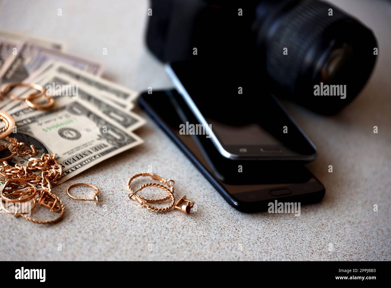 Viele teure goldene Schmuckringe, Ohrringe und Halsketten mit vielen US-Dollar-Scheinen in der Nähe von Smartphones und digitalen spiegelreflexkameras. Pfandhaus Stockfoto