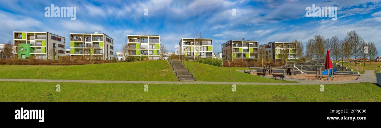 Panoramablick auf moderne Apartmentblöcke mit Spielplatz und Wiese bei Sommerwetter Stockfoto