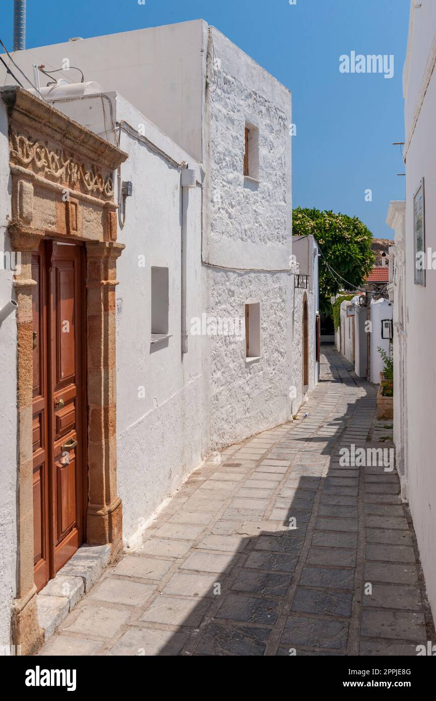 Eine enge Gasse mit weißen, getynchten Häusern im Dorf Lindos auf der griechischen Insel Rhodos in der Ägäis Stockfoto