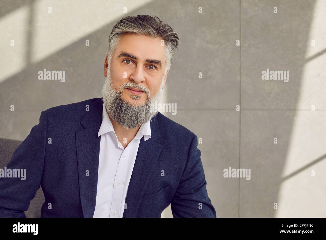 Porträt eines gutaussehenden, grauhaarigen, bärtigen Geschäftsmanns mittleren Alters Stockfoto