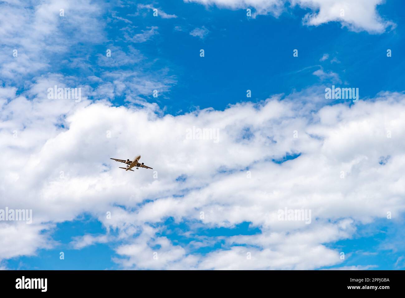 Landungsflugzeug am blauen Himmel mit Wolken Stockfoto