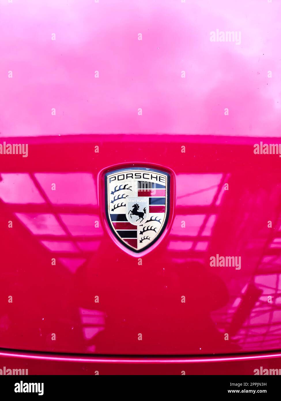 Kiel, Deutschland - 09. November 2022: Porsche-Logo auf der Motorhaube eines roten Sportwagens. Stockfoto