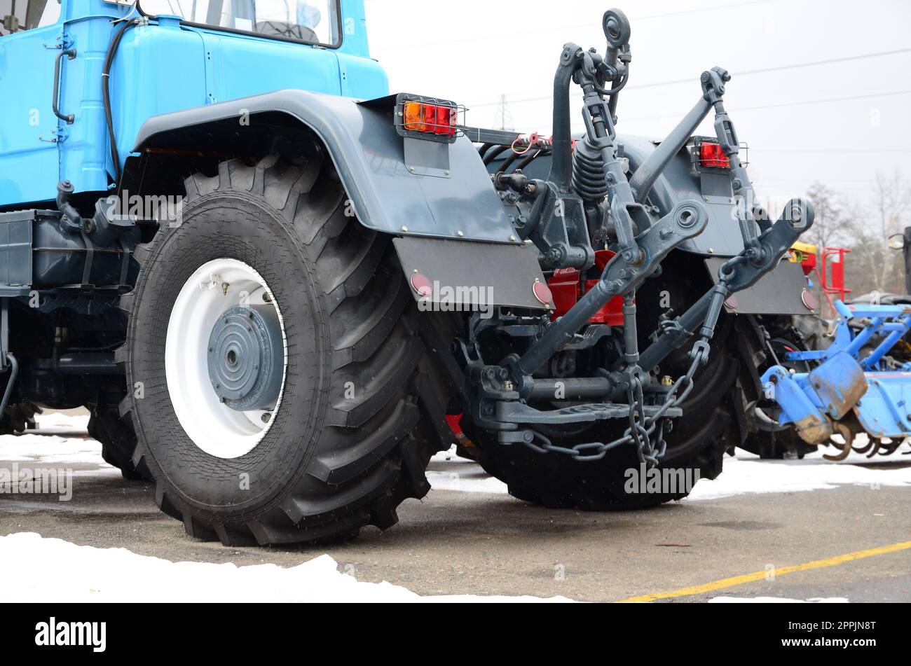 Räder der Rückansicht des neuen Traktors bei schneebedecktem Wetter. Rückansicht des landwirtschaftlichen Fahrzeugs Stockfoto