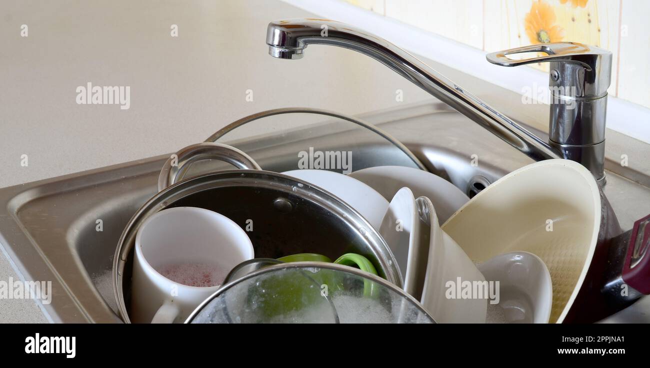 Schmutziges Geschirr und ungewaschene Küchengeräte füllten das Spülbecken Stockfoto