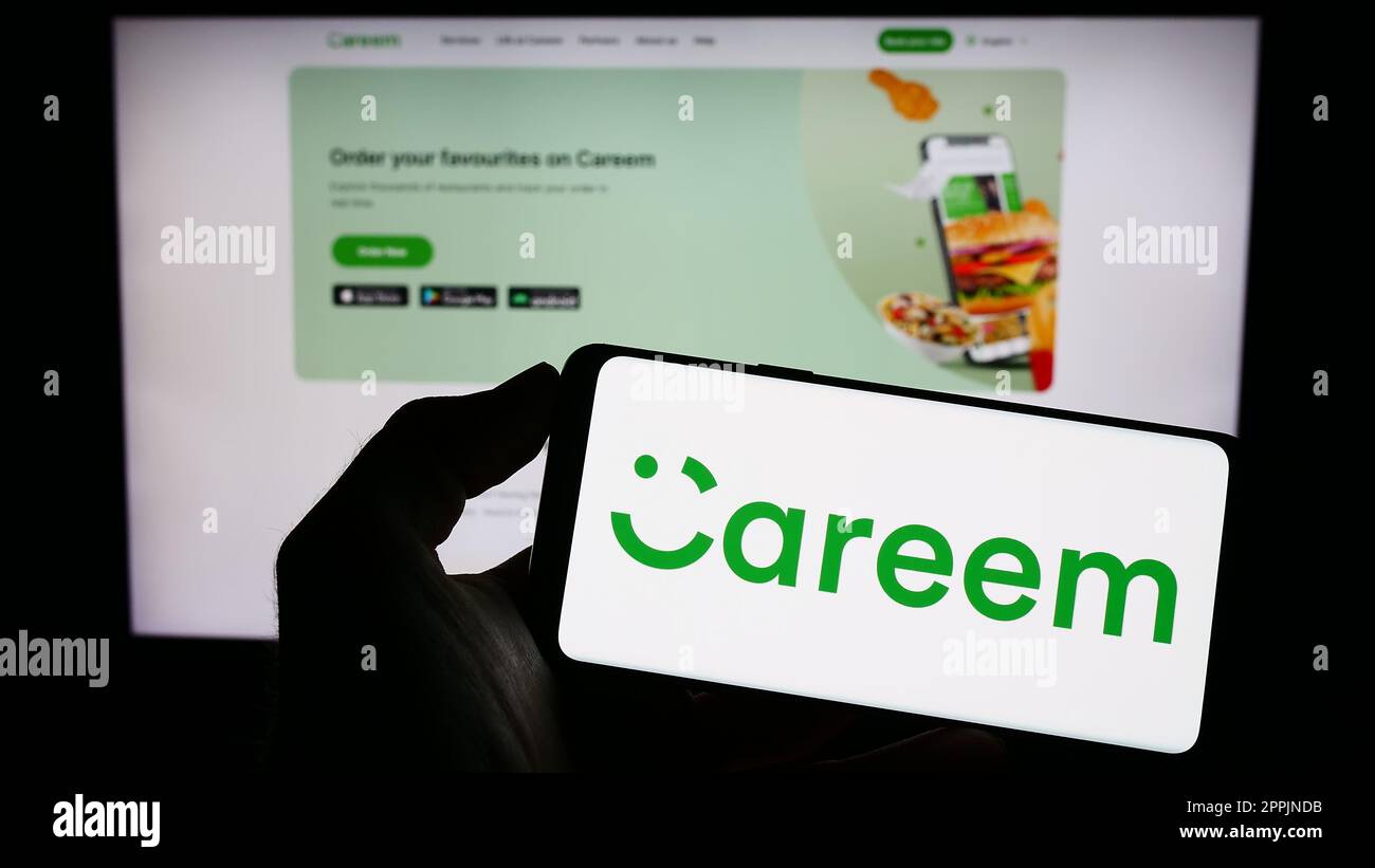 Person, die ein Mobiltelefon mit dem Logo der emiratischen Firma Careem Networks FZ-LLC auf dem Bildschirm vor der Unternehmenswebseite hält. Konzentrieren Sie sich auf das Display des Telefons. Stockfoto