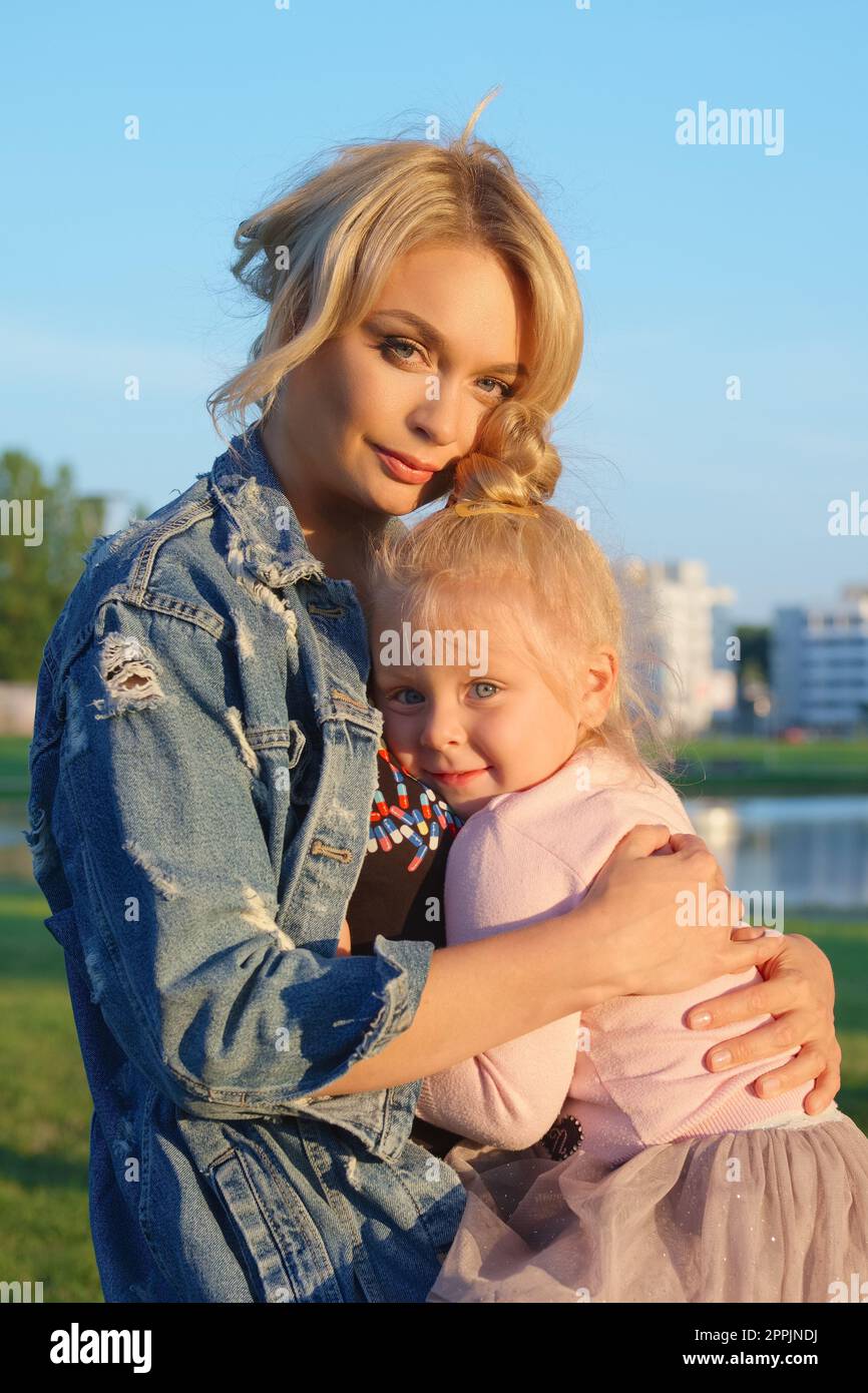 Mutter umarmt ihre kleine Tochter zärtlich Stockfoto
