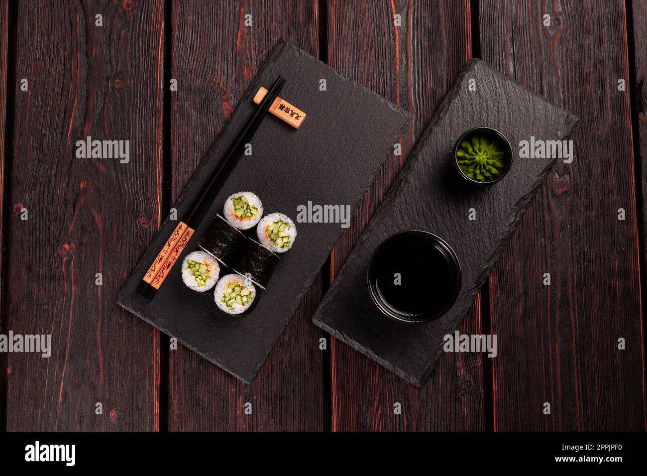 Maki Sushi-Brötchen mit Gurke und Sesam mit Stäbchen, Draufsicht. Sushi-Menü. Japanisches Essen. Stockfoto