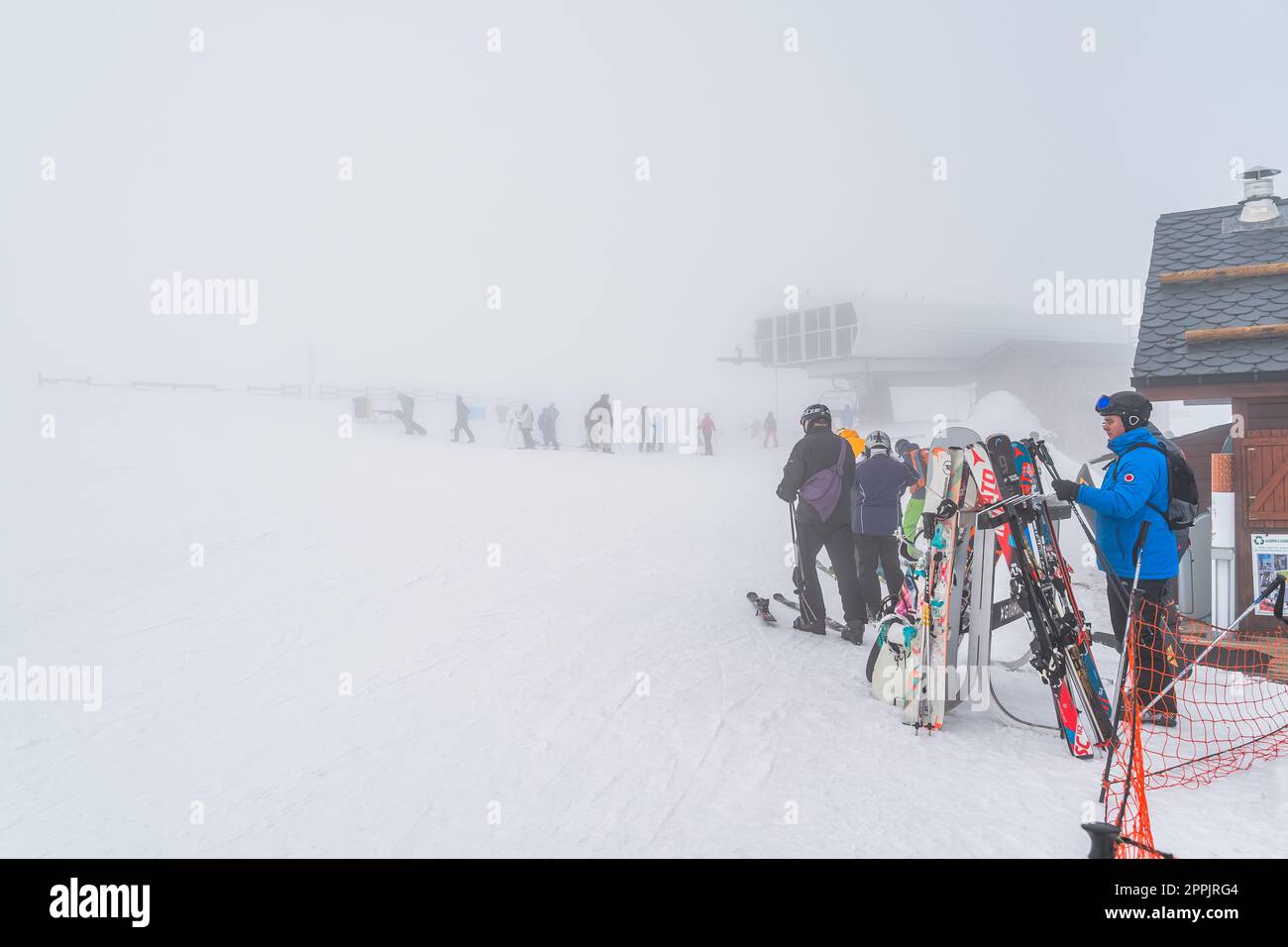 Skifahrer und Snowboarder, die den Skilift auf einem Berg verlassen, schlechte Sicht durch starken Nebel, Andorra Stockfoto