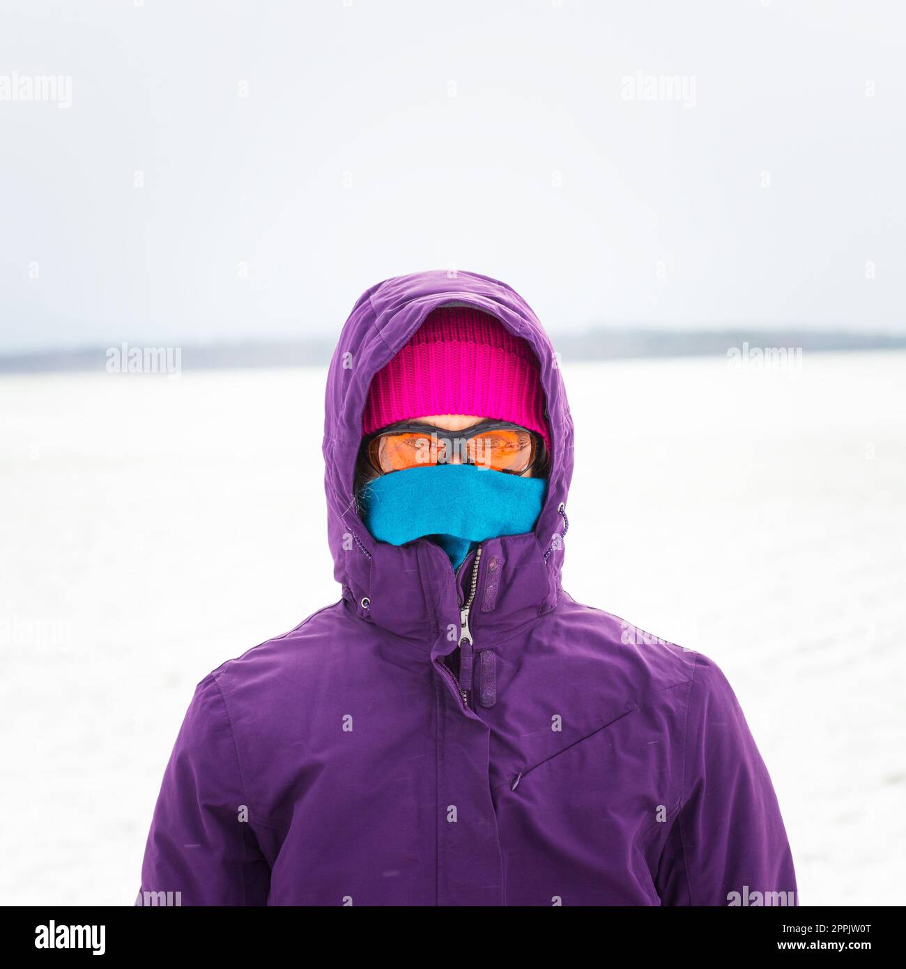 Eine Frau, die im Schnee in Winterkleidung läuft Stockfoto