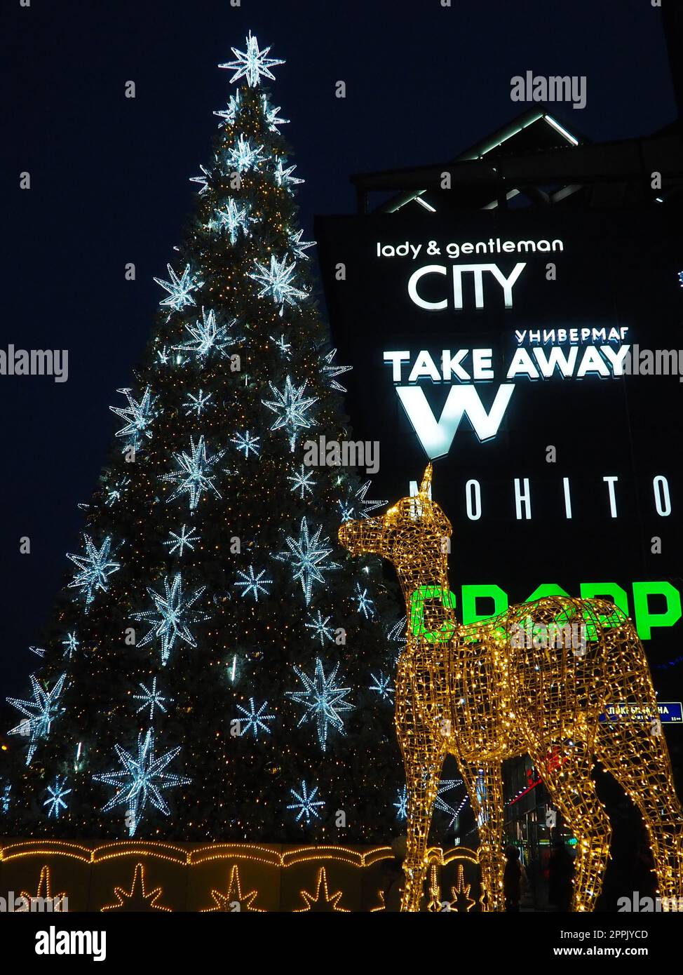 Moskau, Russland, Januar 17 2023. Straße Weihnachtsbaum mit Schneeflocken und festlichen Bällen. U-Bahn Yugo-Zapadnaya. Weihnachtsdekorationen vor dem Einkaufszentrum. Silberne Sterne, Schneeflocken und goldene Hirsche Stockfoto