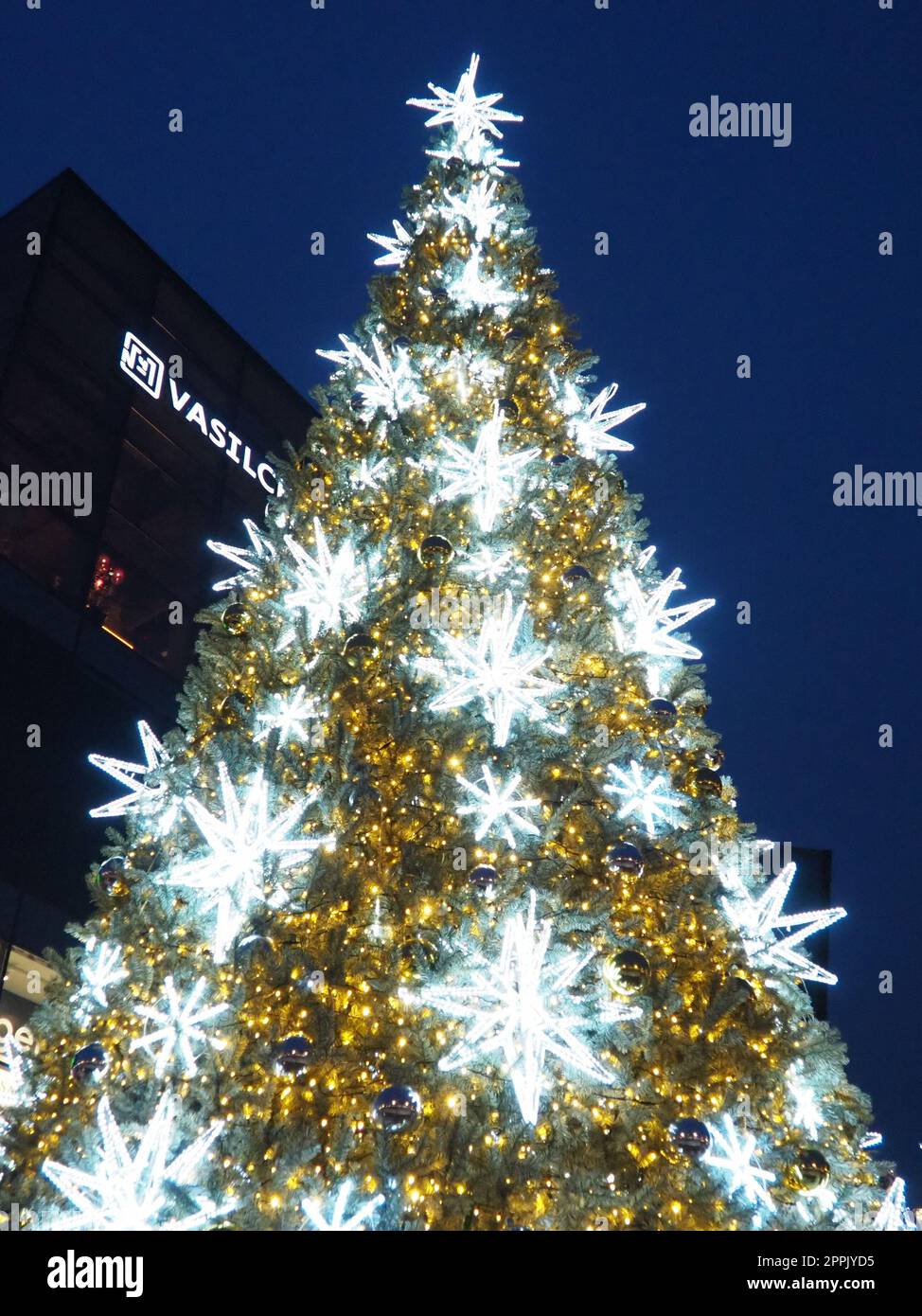 Moskau, Russland, Januar 17 2023. Straße Weihnachtsbaum mit Schneeflocken und festlichen Bällen. U-Bahn Yugo-Zapadnaya. Weihnachtsdekorationen vor dem Einkaufszentrum. Silberne Sterne, Schneeflocken und goldene Girlanden. Stockfoto