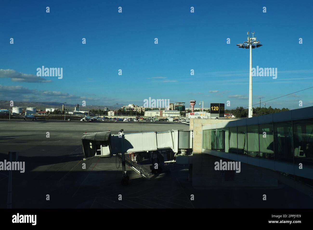 Ankara, Türkei, Flughafen Esenboga Havalimani, 01.19.2023 Aussicht vom Fenster des Passagierterminals auf der Landebahn. Flugzeugbrücke. Turm mit Antenne. Flughafengebäude, Boarding Gate. Himmel Stockfoto