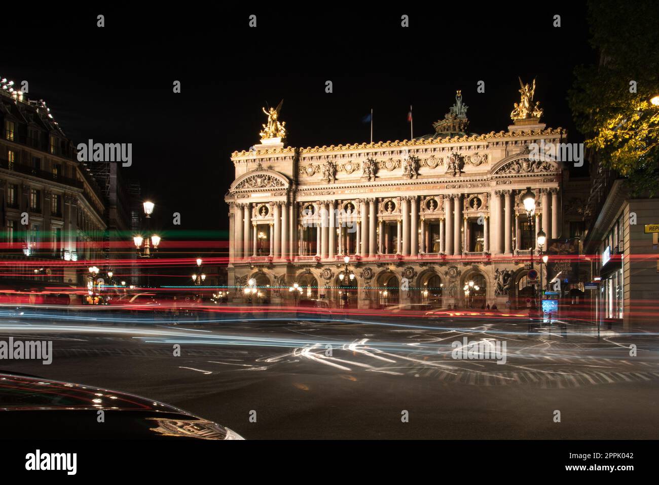 Berühmte Pariser Oper bei Nacht, Lichter des Verkehrs, die umherführen Stockfoto