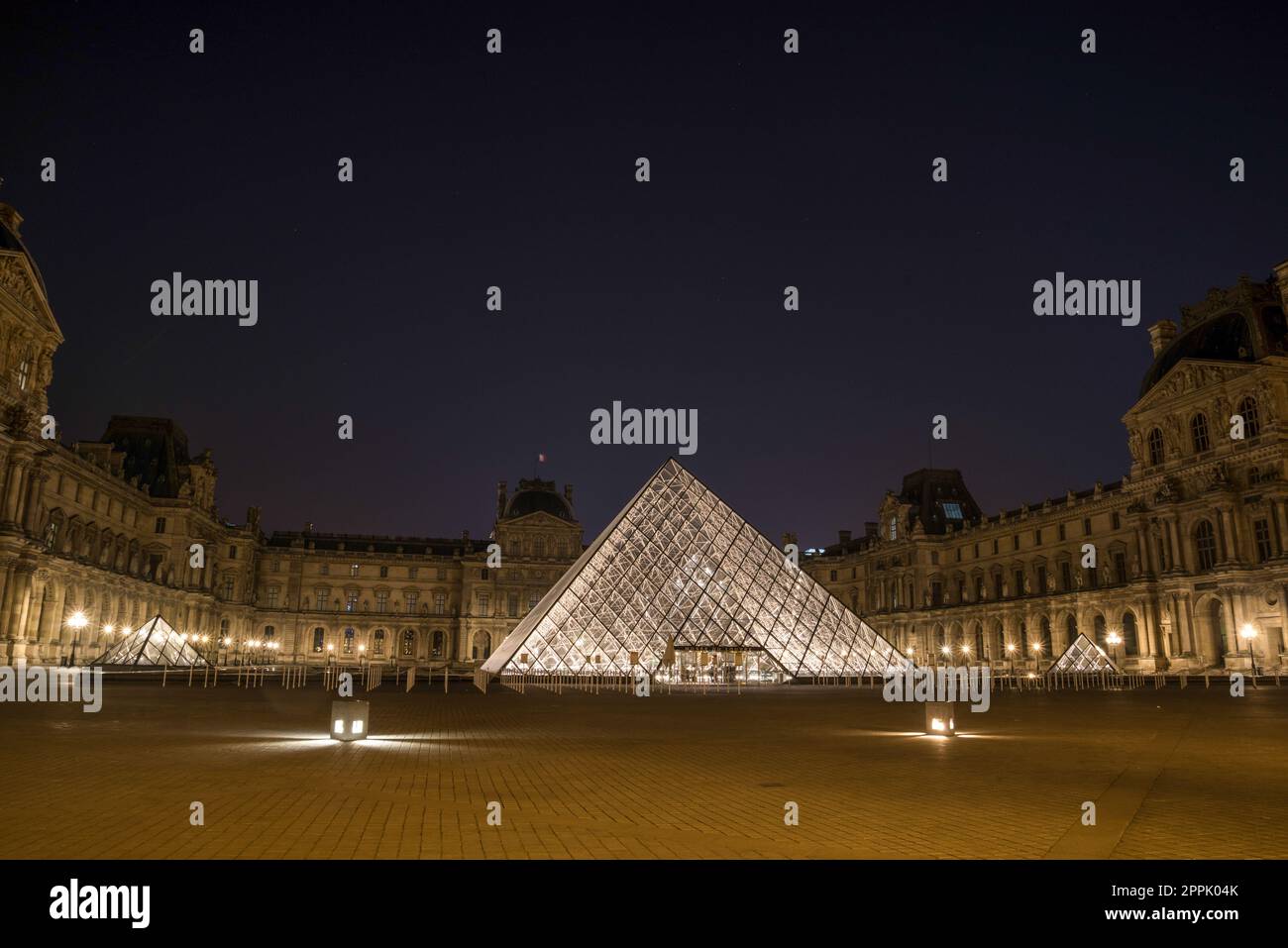 Der berühmte Louvre und seine berühmte Glaspyramide bei Nacht, Paris Stockfoto