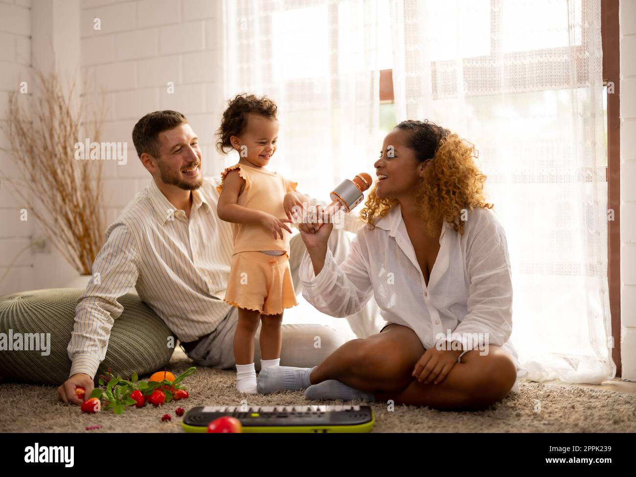 Eltern bringen Kindern bei, wie man geht, Gegenstände hält, sich abwechselt, symbolische Spielzeuge spielt und Gefühle ausdrückt. Liebe, Richtung, Inspiration und Schutz A Stockfoto