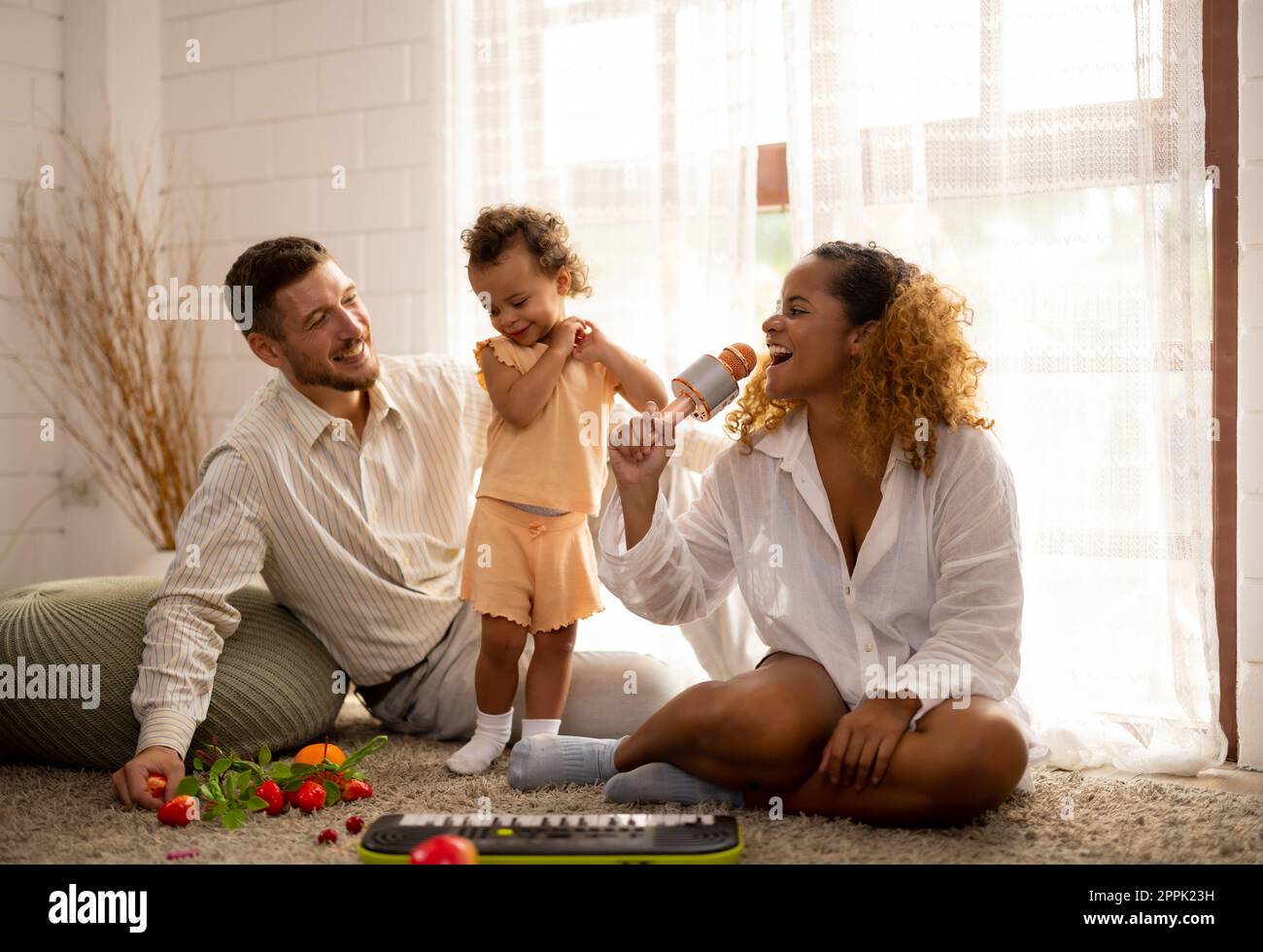 Eltern bringen Kindern bei, wie man geht, Gegenstände hält, sich abwechselt, symbolische Spielzeuge spielt und Gefühle ausdrückt. Liebe, Richtung, Inspiration und Schutz A Stockfoto