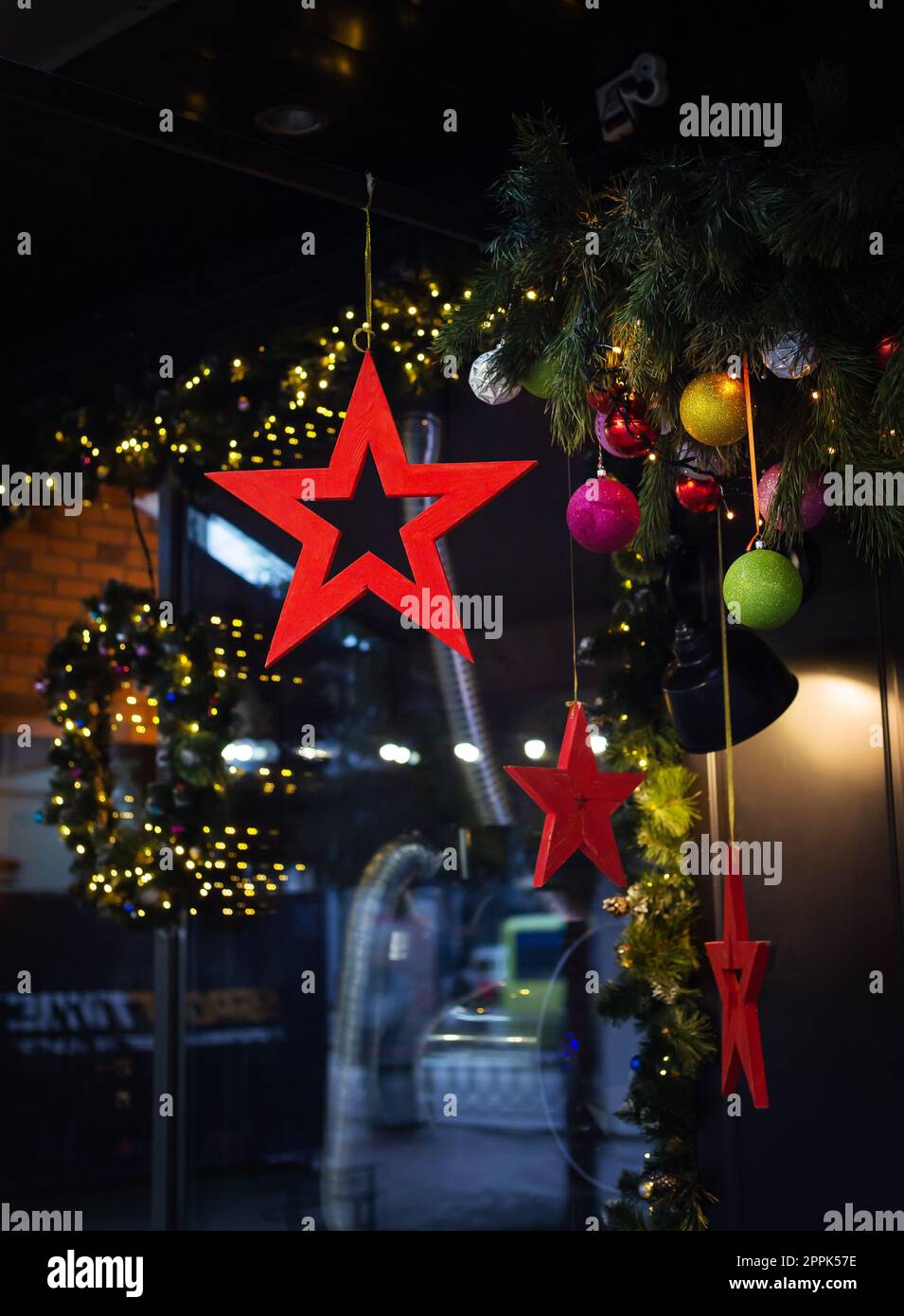 Sehr schöne und helle Schaufenster sind für die Neujahrsfeiertage dekoriert - Sterne, Bälle, Girlanden. Stockfoto