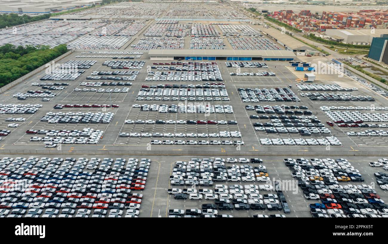 Luftaufnahme des Neuwagenbestands auf dem Werksparkplatz. Von oben sehen Sie viele Autos, die nacheinander geparkt sind. Automobilindustrie. Logistik- und Lieferkettengeschäft. Import oder Export von Neuwagen im Lagerhaus in der Nähe des Hafens. Stockfoto
