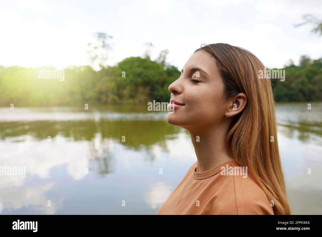 Verbinden Sie sich mit der Natur. Seitenansicht einer jungen Frau mit geschlossenen Augen, die im tropischen Park Brasiliens atmet. Stockfoto