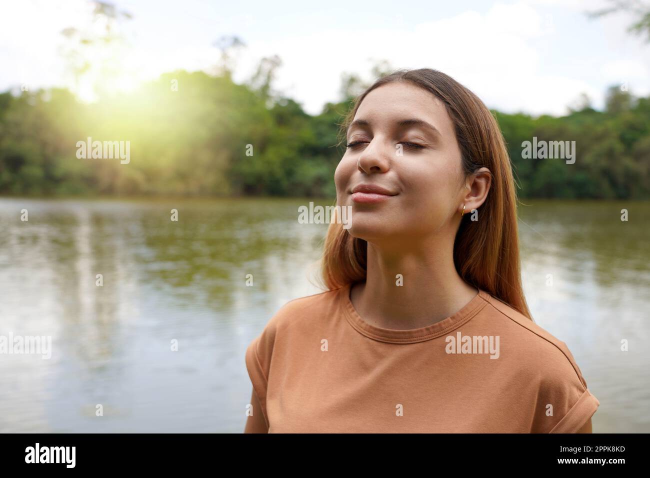 Verbinden Sie sich mit der Natur. Junge Frau mit geschlossenen Augen, die im tropischen Park Brasiliens atmet. Stockfoto