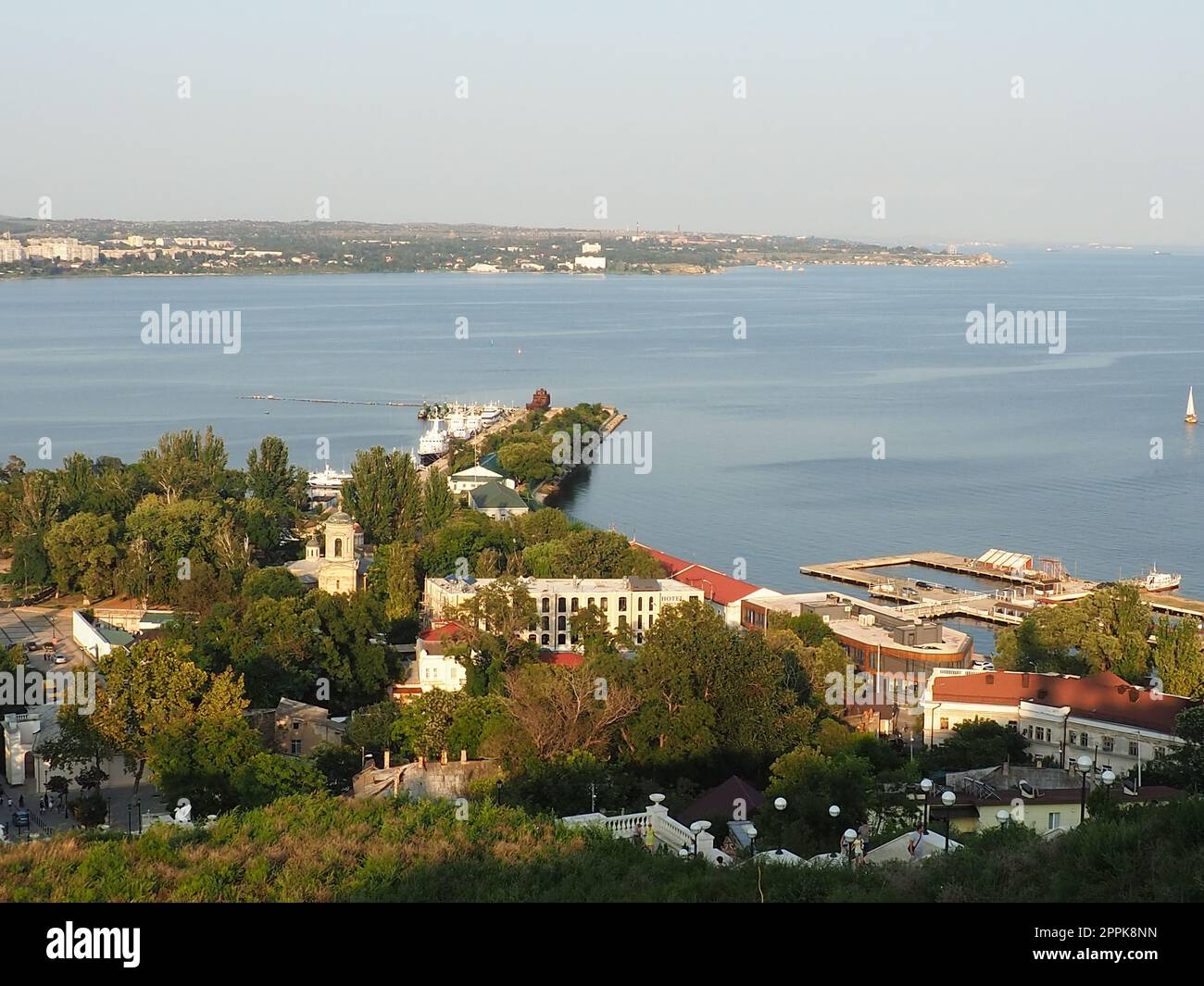 Kerch 21. August 2021 Blick auf die Stadt Kerch von der Aussichtsplattform auf dem Berg Mithridat. Häuser, Bäume, Schwarzes und Asowisches Meer, Seehafen. Cove und gegenüber der Küste mit Horizont. Sommerabend Stockfoto