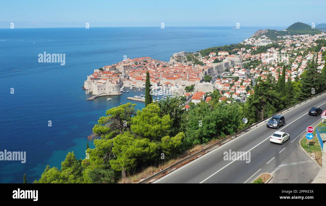 Straßenverkehr in der Nähe der Altstadt von Dubrovnik in Kroatien. Dubrovnik Ragusa ist eine Stadt in Kroatien, dem Verwaltungszentrum des Bezirks Dubrovnik-Neretva. Blick von oben von der Aussichtsplattform auf den Felsen. Stockfoto