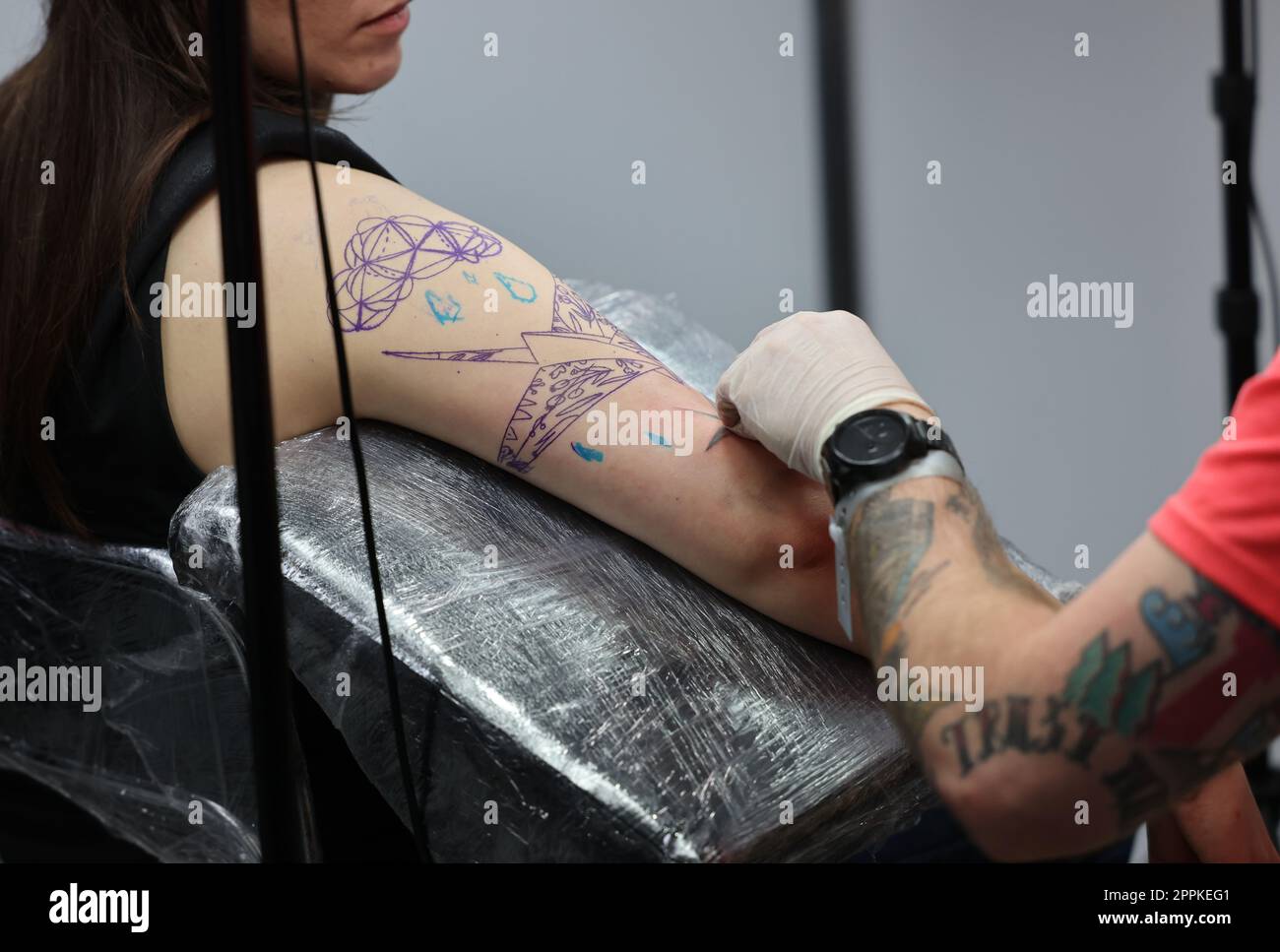 Nicht identifizierter Teilnehmer bei der 15. Tattoofest Convention in Krakau. Tattoo-Künstler bei der Arbeit. Stockfoto