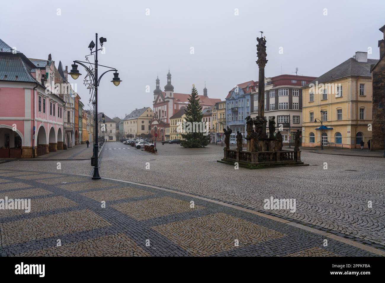 CHOMUTOV, TSCHECHISCHE REPUBLIK - 04. DEZEMBER 2022: Straßen der Altstadt vor Weihnachten. Der Platz der Altstadt, im Vordergrund, ist die Säule der Heiligen Dreifaltigkeit. Stockfoto