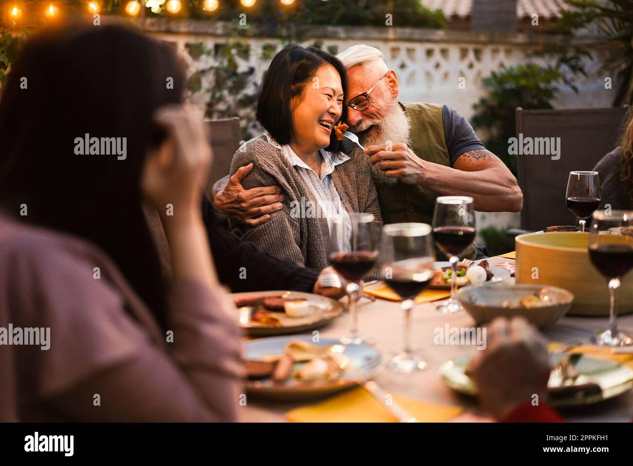 Glückliche Senioren, die Spaß beim Barbecue-Dinner haben - Fokus auf Seniorenhände Stockfoto