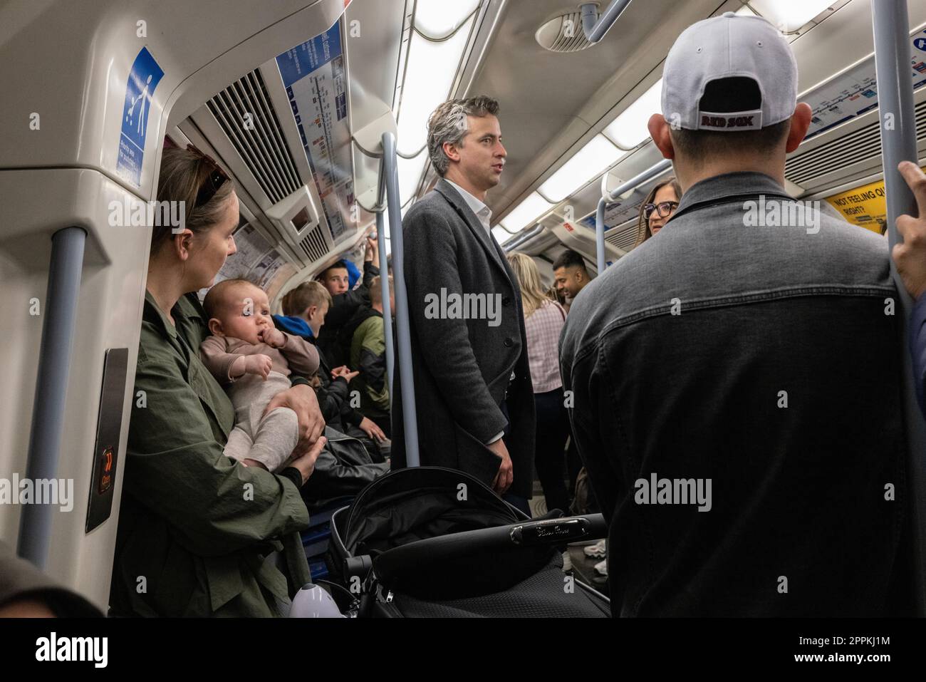 Pendler, darunter eine junge Mutter mit einem Baby, reisen in der Londoner U-Bahn während der Hauptverkehrszeit in London, England, Großbritannien Stockfoto