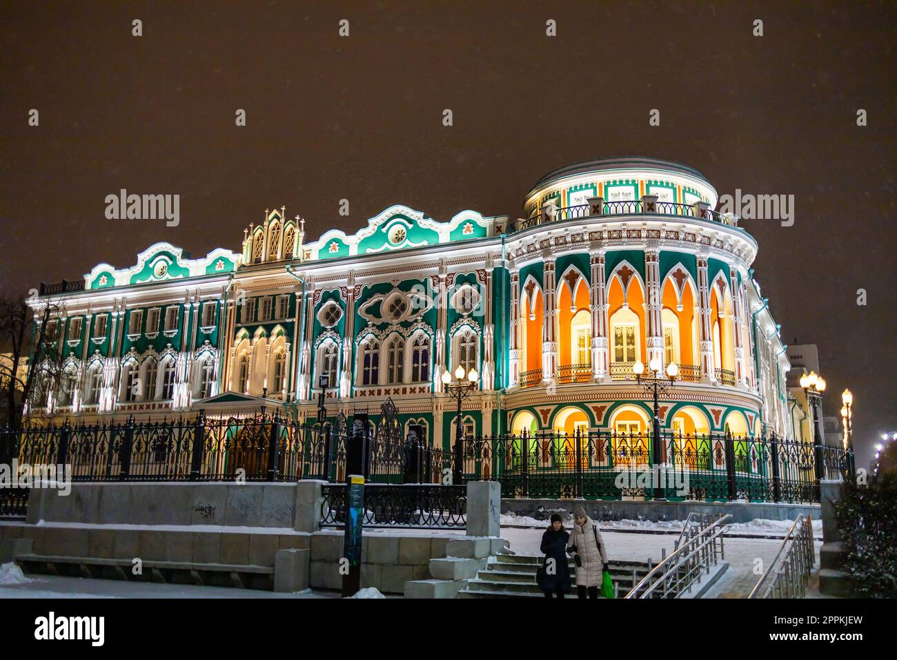 JEKATERINBURG, 18. Dezember 2021: Sevastyanow Haus auch Haus der Gewerkschaften in Jekaterinburg in Russland bei Nacht und Winter. Es ist ein Palast, der im ersten Viertel des 19. Jahrhunderts am Ufer des Stadtteiches erbaut wurde und von einem Staudamm am Iset River gebildet wurde. Stockfoto