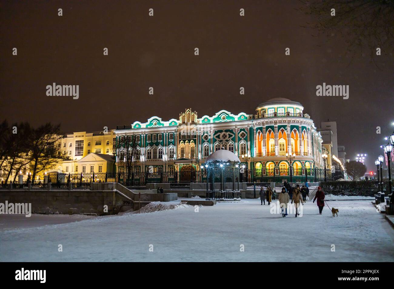 JEKATERINBURG, 18. Dezember 2021: Sevastyanow Haus auch Haus der Gewerkschaften in Jekaterinburg in Russland bei Nacht und Winter. Es ist ein Palast, der im ersten Viertel des 19. Jahrhunderts am Ufer des Stadtteiches erbaut wurde und von einem Staudamm am Iset River gebildet wurde. Stockfoto