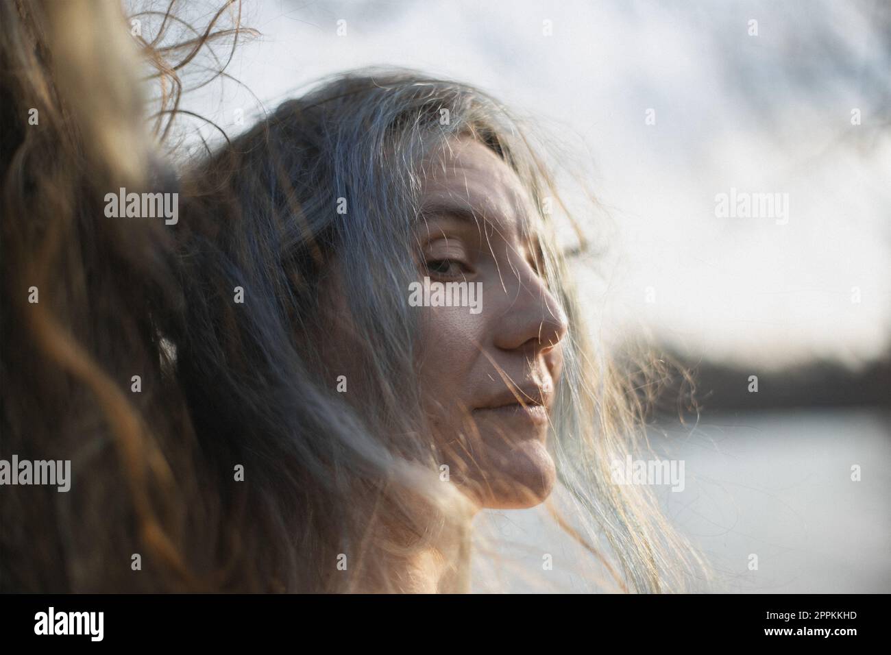 Nahaufnahme einer erwachsenen Dame mit silbernem Haar, die aus dem Augenwinkel des Porträts schaut Stockfoto