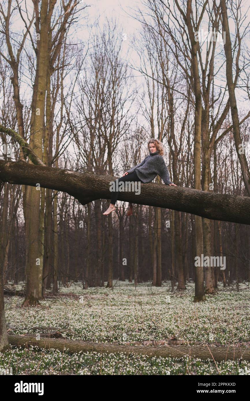 Anmutige Frau, die sich auf dem Fallschirm über Blumen ausruht, malerische Fotografie Stockfoto