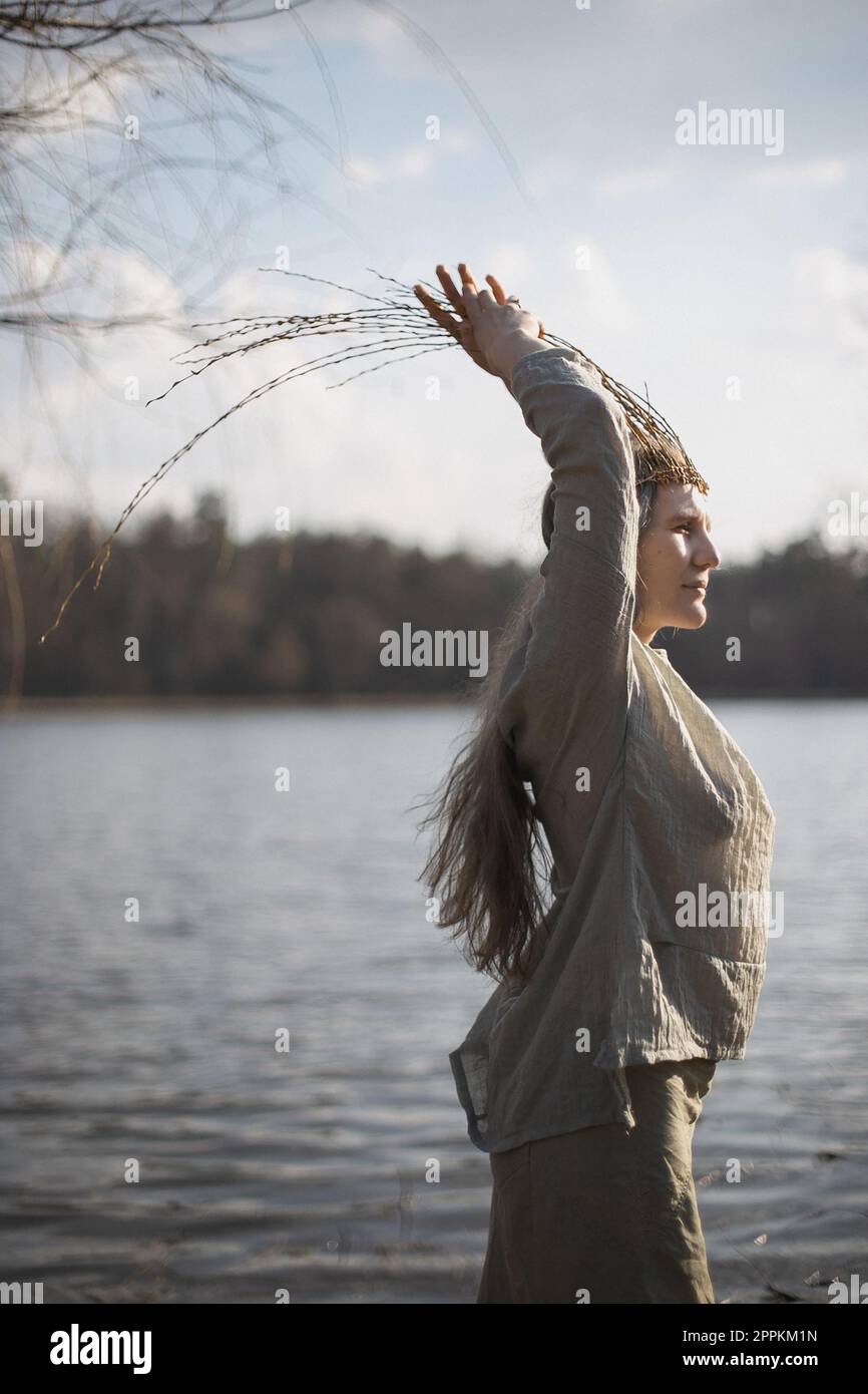 Nahaufnahme einer authentischen Frau, die sich vor dem See in einem Porträtbild von heidnischen Outfits posiert Stockfoto