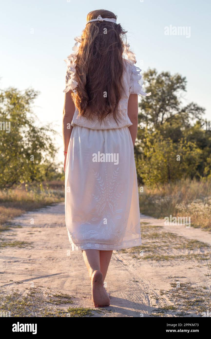 Nahaufnahme der wunderschönen barfuß Frau in weißem Kleid beim Spaziergang Konzeptfoto Stockfoto