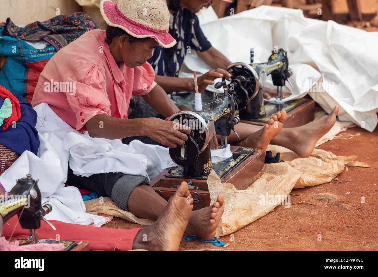 Straßenschneider arbeiten mit ihren veralteten manuellen Nähmaschinen. In Madagaskar etwas Geld zu verdienen, ist sehr schwierig Stockfoto